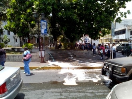 Con una manguera comenzó a echar agua a los presentes alegando que limpiaba la plaza