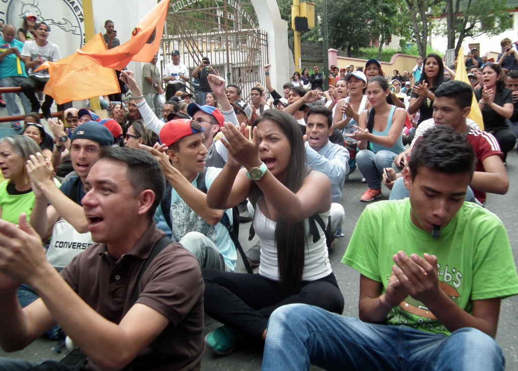 Jóvenes se sientan en la calle y gritan consignas exigiendo al CNE fecha para revocar a Maduro.  