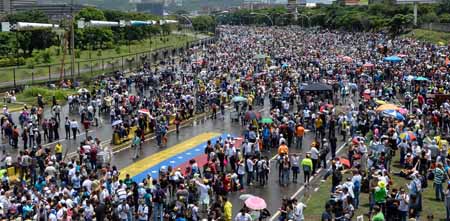 "PLANTÓN" EN CARACAS. Cubriéndose con paraguas o capas de la lluvia que ha caído de forma intermitente, miles de personas estuvieron apostadas en la neurálgica autopista Francisco Fajardo, en el este de Caracas.