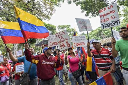 Los manifestantes, varios de ellos con camisas que tenían estampado el rostro del fallecido expresidente Hugo Chávez, portaban carteles que decían "fiscal, te vendiste por unos dólares"