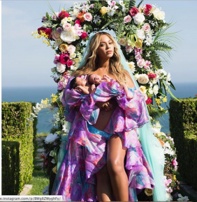 Vestida con una especie de velo azul y un vestido estampado, descalza y mostrando las piernas, la cantante de "Single Ladies", de 35 años, tiene en brazos a sus gemelos nacidos en Los Ángeles